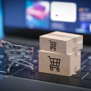 A laptop with two boxes and a shopping cart on top of it.