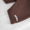 Brown shorts with "HEAVY" text on fabric.