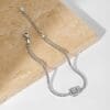 Silver bracelet on stone surface.