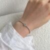 Hand wearing elegant silver bracelet.