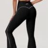 Black leggings with white detailing, woman pose.