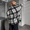 Woman wearing black and white plaid shirt.