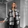 Young woman in a plaid shirt indoors.