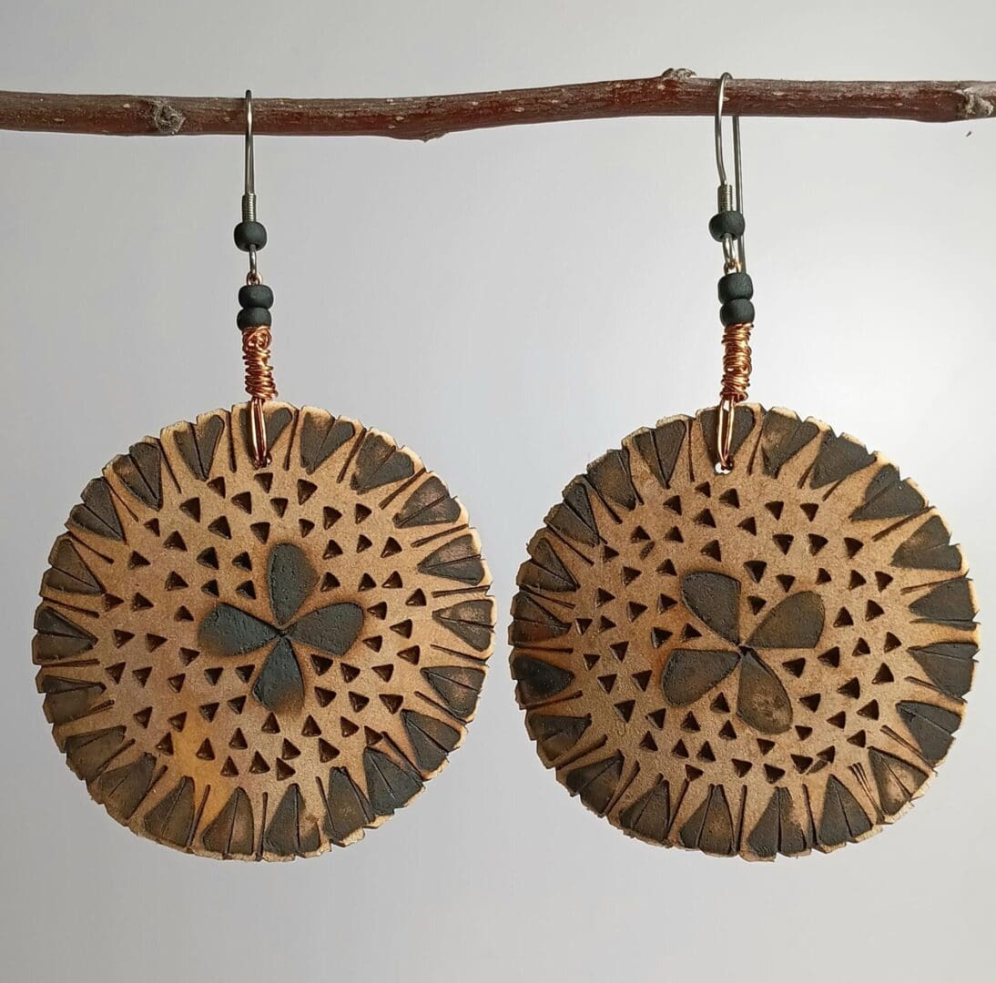 Handcrafted circular earrings with geometric designs.