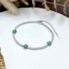 Diamond bracelet with green floral accents.
