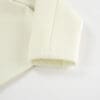 Cream fabric with textured sleeve detail.