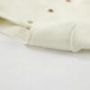 Cream-colored fabric with decorative buttons.