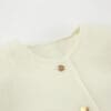 Light cream textured fabric with gold button.