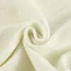Cream-colored fabric in a spiral fold.