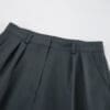 Dark green high-waisted pleated pants.